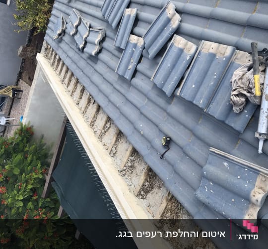 רעפים מונחים על גג עם כלי עבודה וחומרי איטום